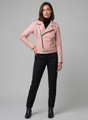Full-length view of a woman in a light pink leather biker jacket with black trousers