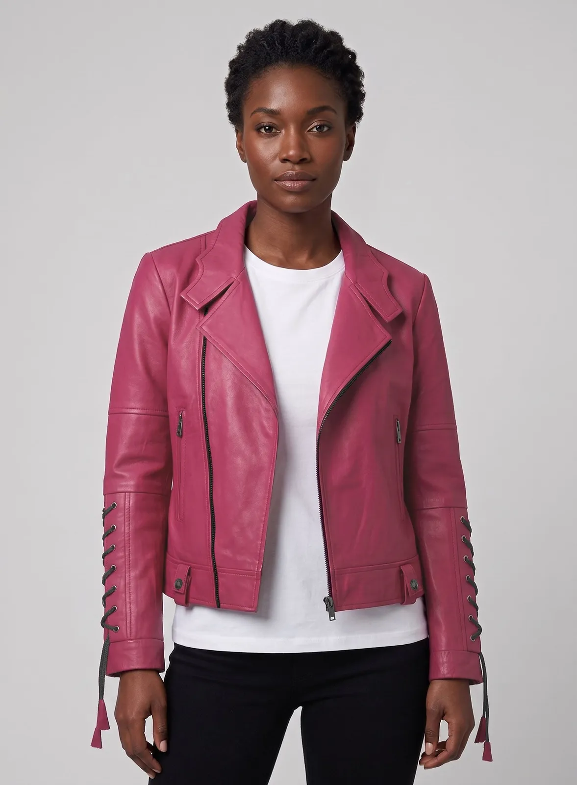 Woman wearing a pink leather biker jacket with lace-up sleeves and tassels