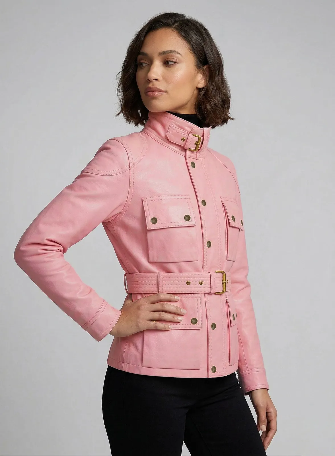 Woman wearing a light pink leather field jacket with buckled collar and belted waist