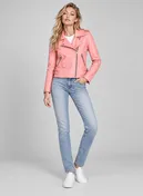 Full-length view of a woman wearing a pink leather biker jacket, jeans and white sneakers