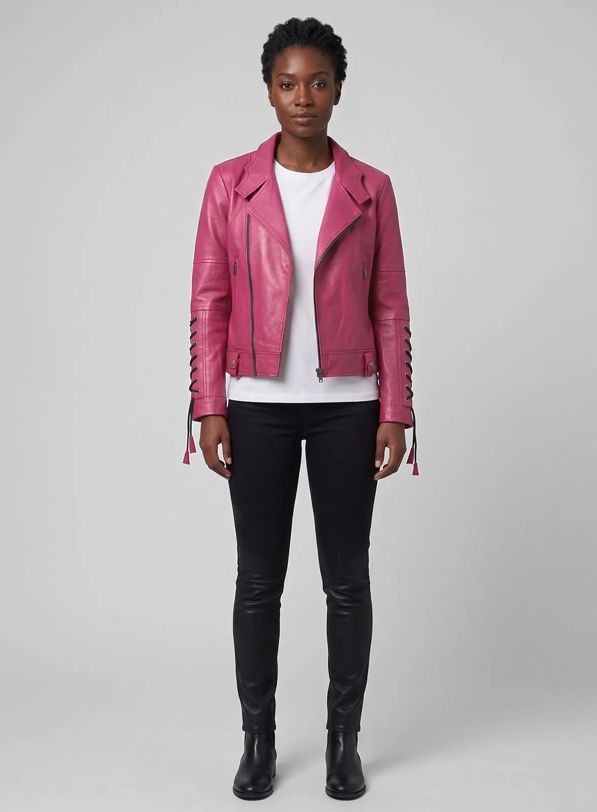 Full-length view of a woman in a pink leather biker jacket with lace-up sleeves