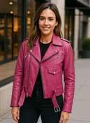 Woman wearing a fuchsia pink leather biker jacket with silver zippers and belted waist